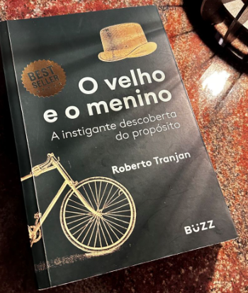 Livro O Velho e o Menino, de Roberto Tranjan, sobre uma superfície de mármore