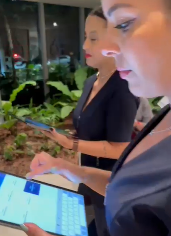 Equipe registrando presença de participantes em evento por meio de tablet