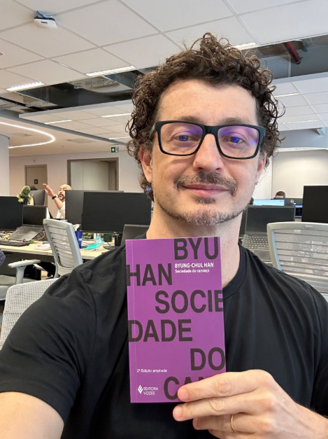 Cezar Cattani segurando o livro Sociedade do Cansaço, de Byung-Chul Han